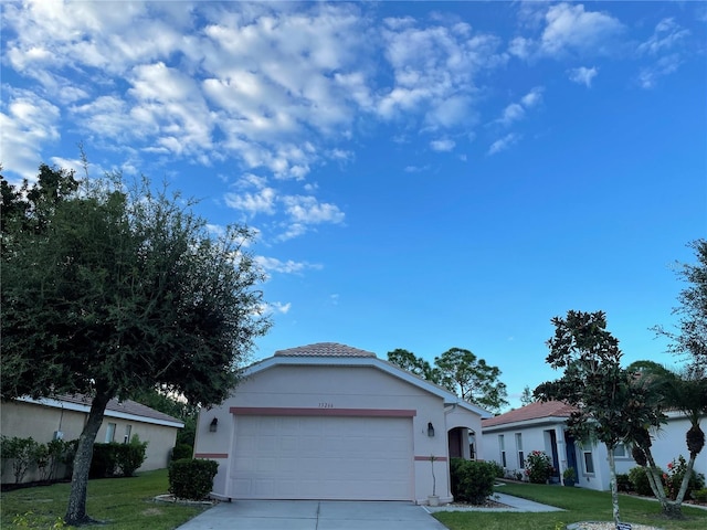 ranch-style home with a garage and a front yard