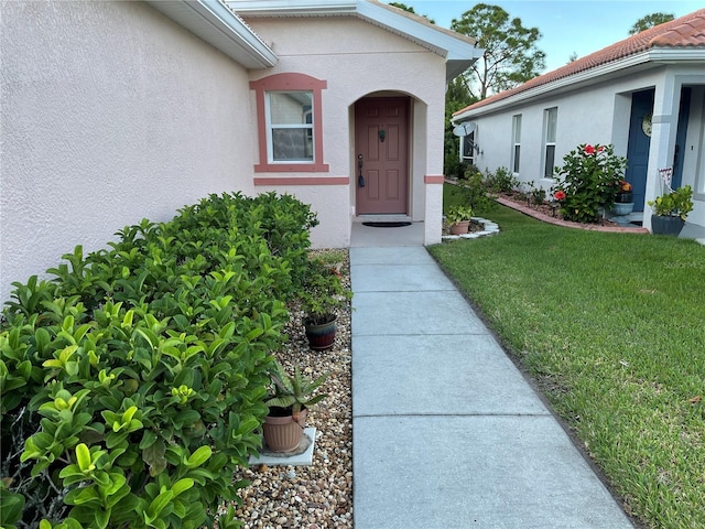 doorway to property featuring a lawn