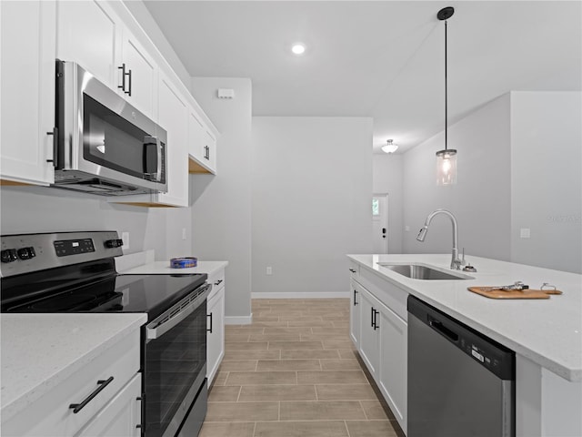 kitchen featuring white cabinets, hanging light fixtures, sink, and appliances with stainless steel finishes