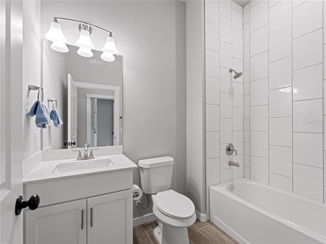 full bathroom featuring hardwood / wood-style flooring, vanity, tiled shower / bath combo, and toilet