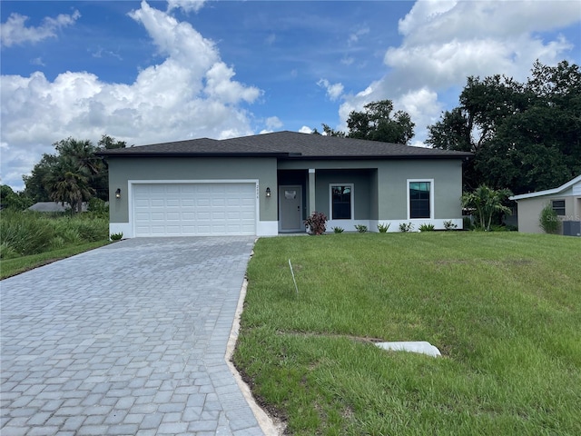 view of front of home with cooling unit, a garage, and a front yard