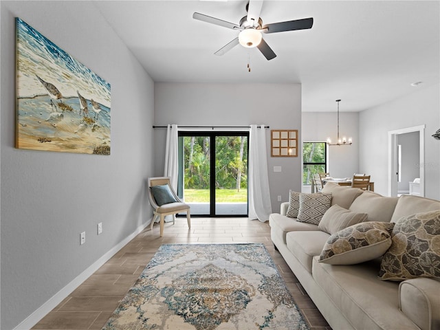 living room with ceiling fan with notable chandelier and hardwood / wood-style flooring