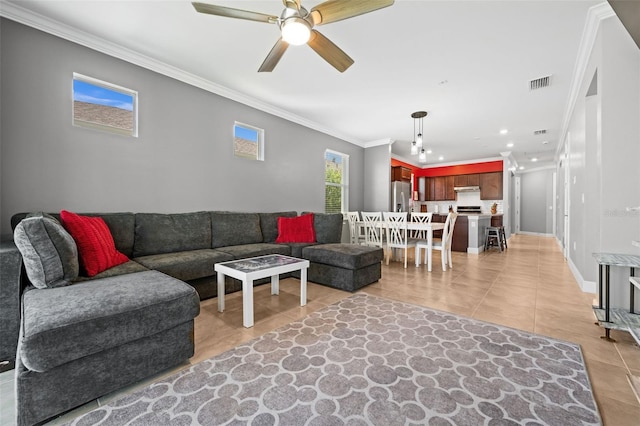 tiled living room with ceiling fan and ornamental molding