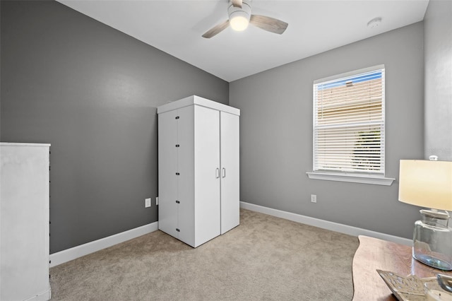 interior space featuring light carpet and ceiling fan