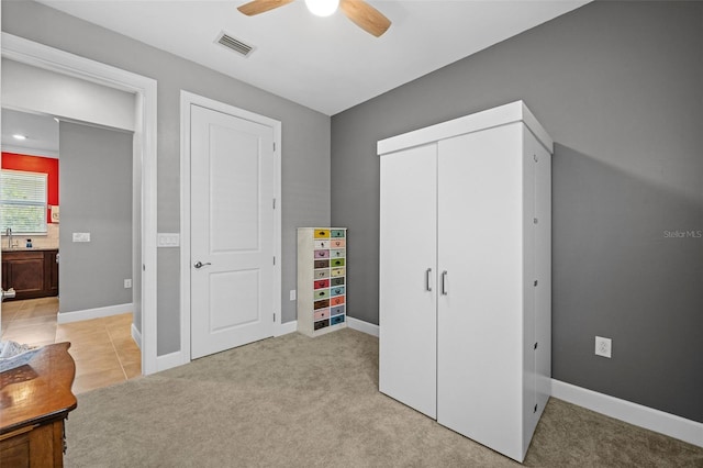 bedroom featuring light colored carpet and ceiling fan