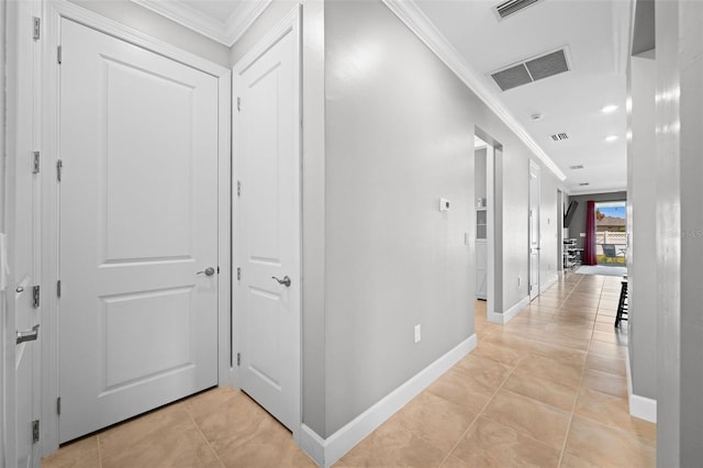 corridor with light tile patterned floors and crown molding