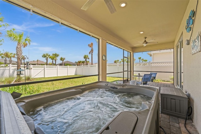 sunroom / solarium featuring ceiling fan and a jacuzzi