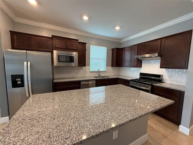 kitchen featuring sink, a kitchen island, light tile patterned flooring, light stone counters, and stainless steel appliances