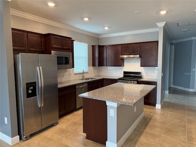 kitchen with sink, light tile patterned floors, appliances with stainless steel finishes, a kitchen island, and light stone counters