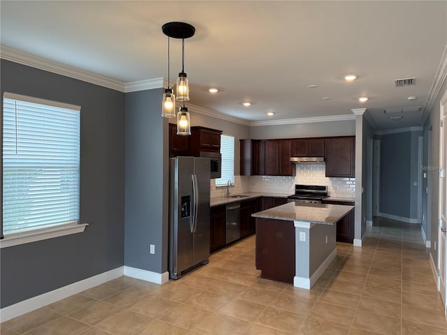 kitchen featuring hanging light fixtures, tasteful backsplash, light stone counters, a kitchen island, and appliances with stainless steel finishes