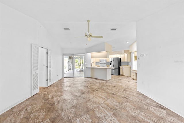 unfurnished living room featuring ceiling fan, sink, and lofted ceiling