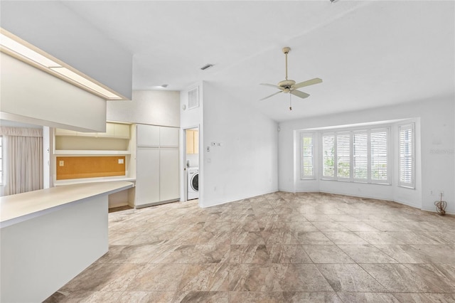 unfurnished living room featuring washer / clothes dryer, ceiling fan, and high vaulted ceiling