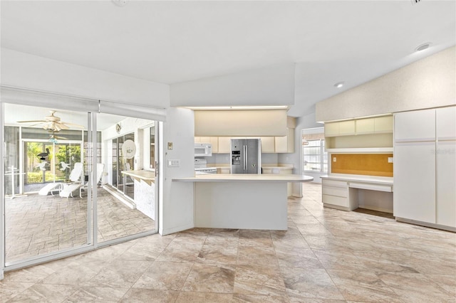 kitchen with plenty of natural light, ceiling fan, white appliances, and vaulted ceiling