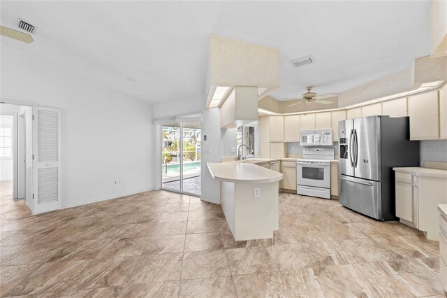 kitchen with kitchen peninsula, ceiling fan, sink, and white appliances