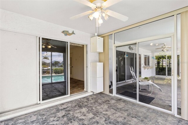 unfurnished sunroom featuring ceiling fan