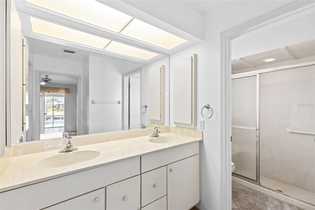 bathroom featuring an enclosed shower, vanity, ceiling fan, tile patterned flooring, and toilet