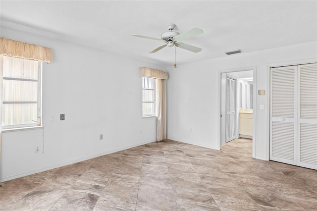 unfurnished bedroom featuring ceiling fan, a closet, and ensuite bathroom