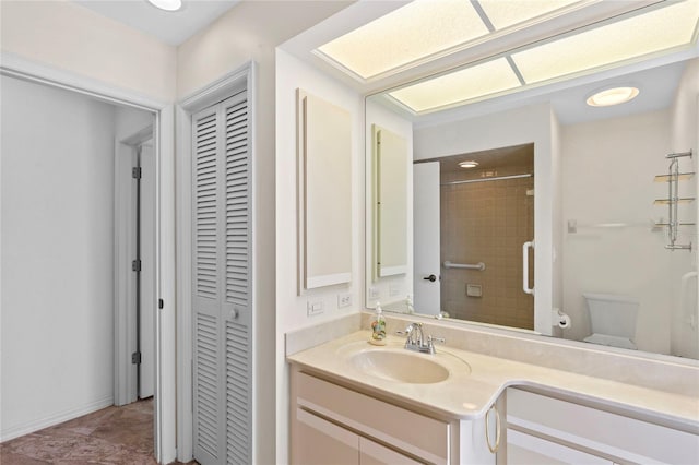 bathroom with vanity, toilet, and a tile shower