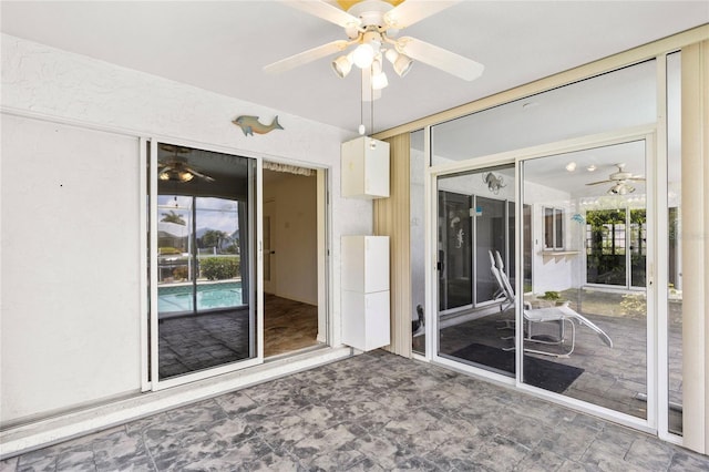 unfurnished sunroom with ceiling fan