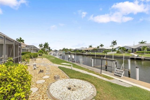 view of yard featuring a water view, a dock, and glass enclosure