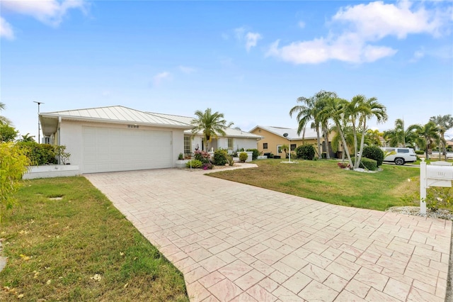 single story home featuring a garage and a front lawn