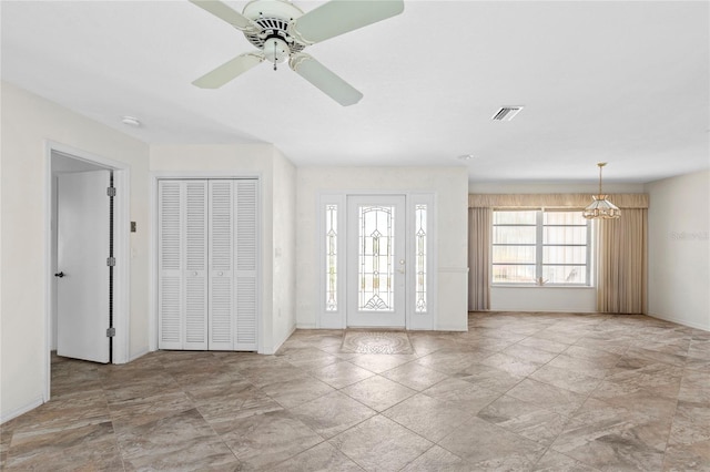 foyer with ceiling fan with notable chandelier