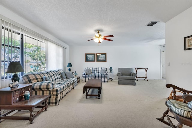 living room with carpet, a textured ceiling, and ceiling fan