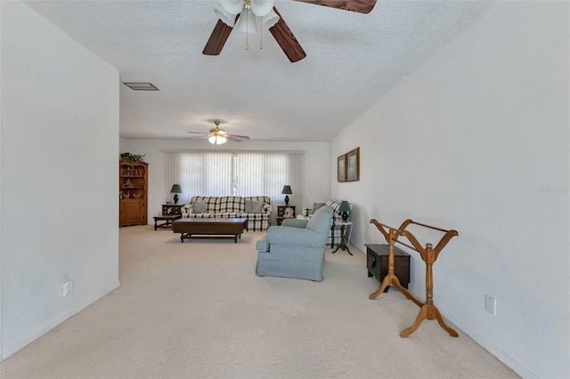 carpeted living room featuring ceiling fan and a textured ceiling