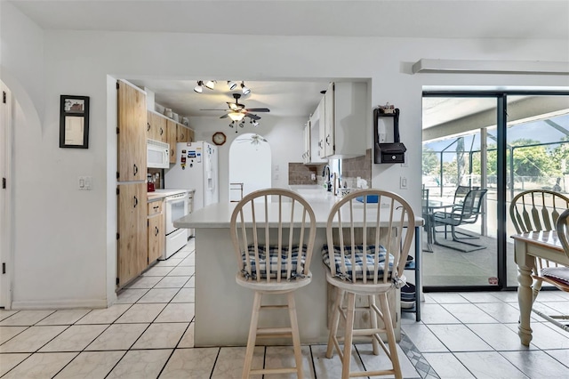 kitchen featuring light tile patterned floors, white appliances, and ceiling fan