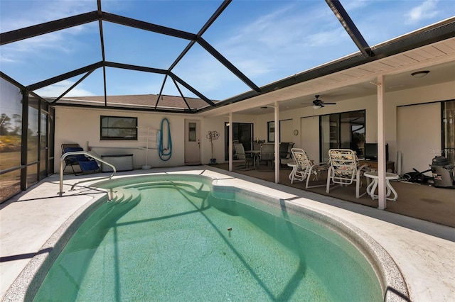 view of swimming pool featuring a patio, glass enclosure, and ceiling fan