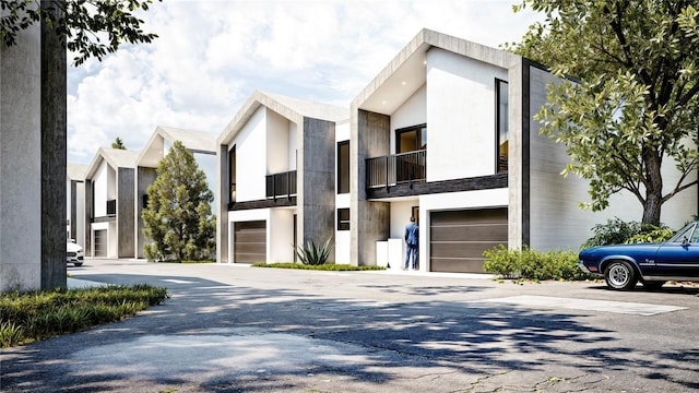 contemporary home with stucco siding, an attached garage, and driveway