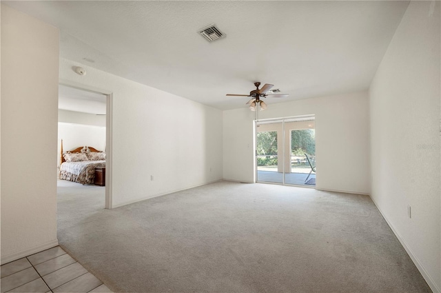 empty room featuring light colored carpet and ceiling fan