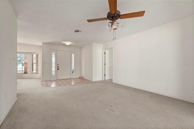 interior space featuring light carpet and ceiling fan