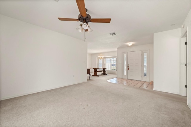 interior space featuring light carpet and ceiling fan with notable chandelier