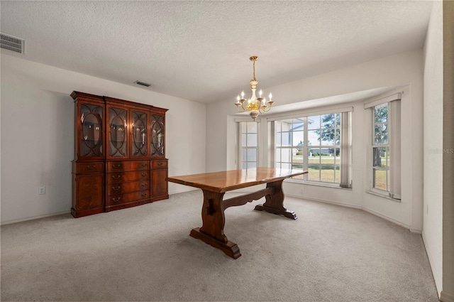 interior space with light carpet, a textured ceiling, and a notable chandelier