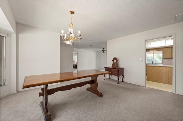 dining space featuring light carpet, ceiling fan with notable chandelier, and a textured ceiling