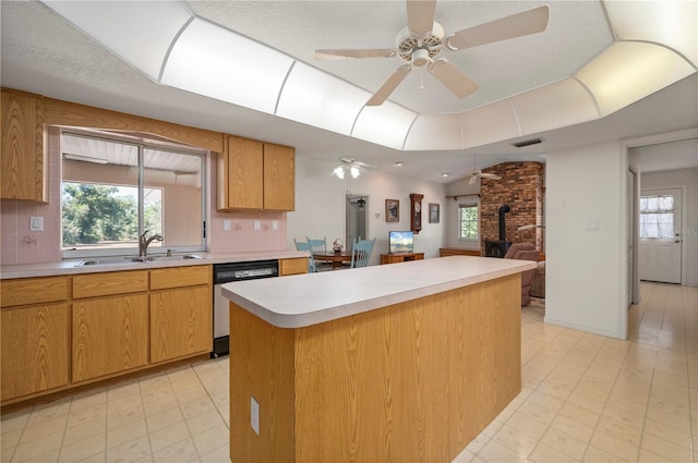 kitchen featuring tasteful backsplash, a wood stove, sink, and stainless steel dishwasher