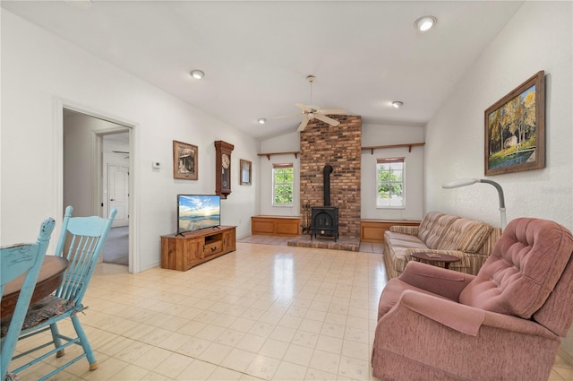 living room featuring a wood stove, ceiling fan, and lofted ceiling