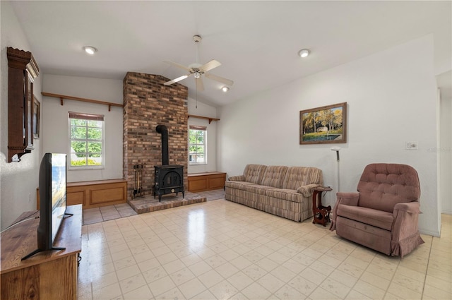 living room featuring lofted ceiling, a wood stove, and a wealth of natural light