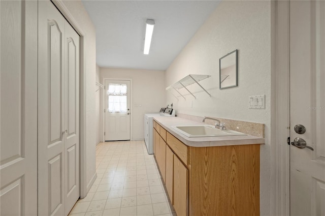 washroom with cabinets, washer and clothes dryer, and sink