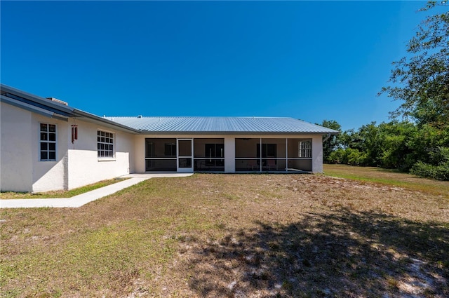 rear view of property featuring a sunroom and a yard