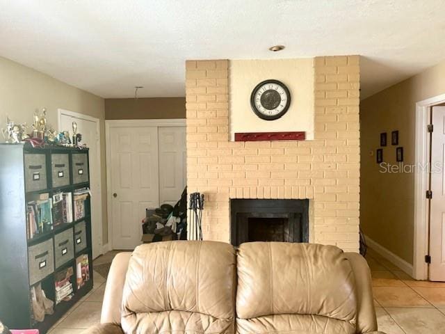 living room with light tile patterned floors and a brick fireplace