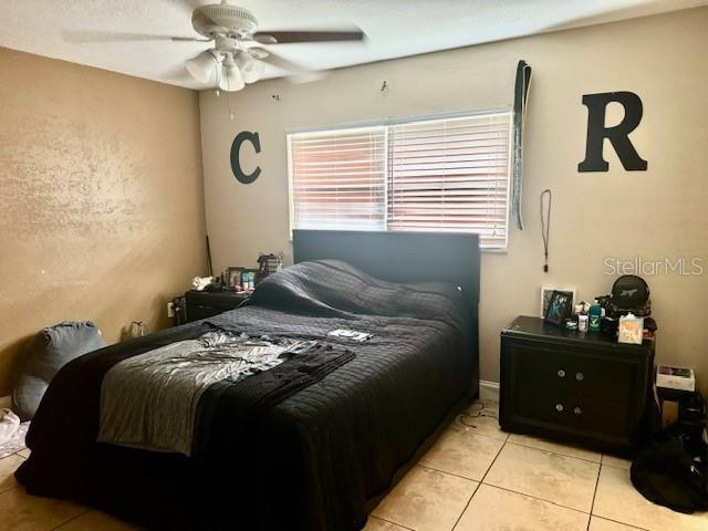 bedroom with light tile patterned floors and ceiling fan