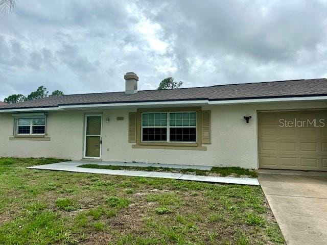 ranch-style home featuring stucco siding, a shingled roof, concrete driveway, a garage, and a front lawn