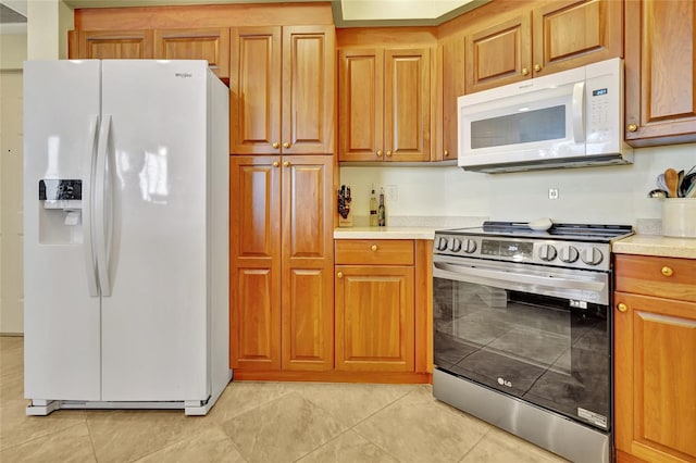 kitchen featuring light tile patterned floors and white appliances