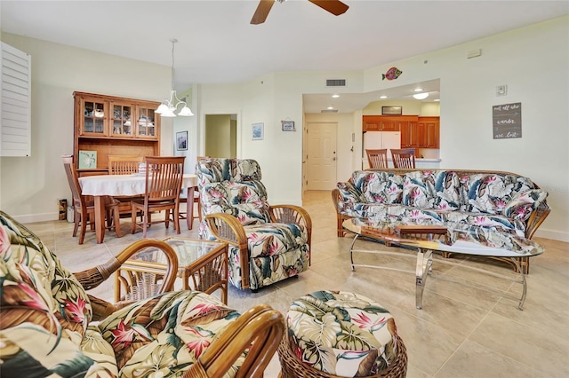 tiled living room with ceiling fan with notable chandelier