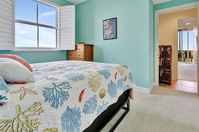 bedroom with light carpet and multiple windows