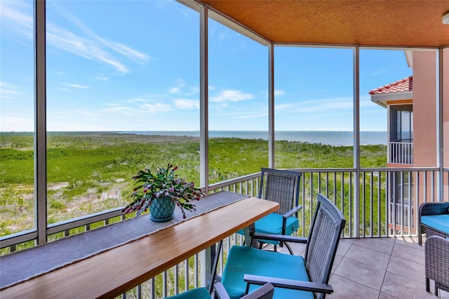 sunroom / solarium featuring a water view and a healthy amount of sunlight