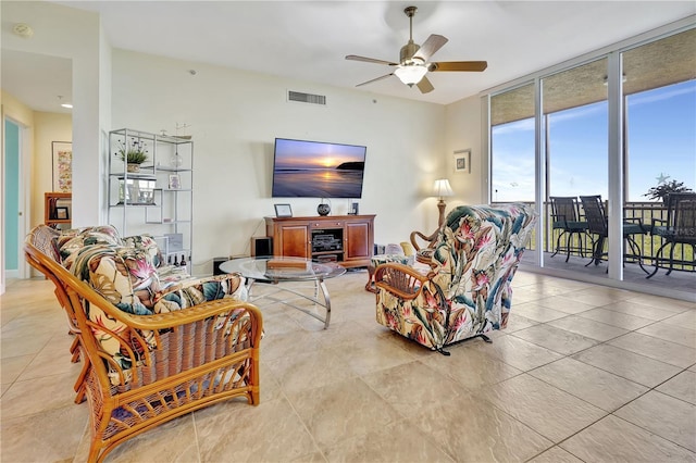 living room with ceiling fan and a wall of windows