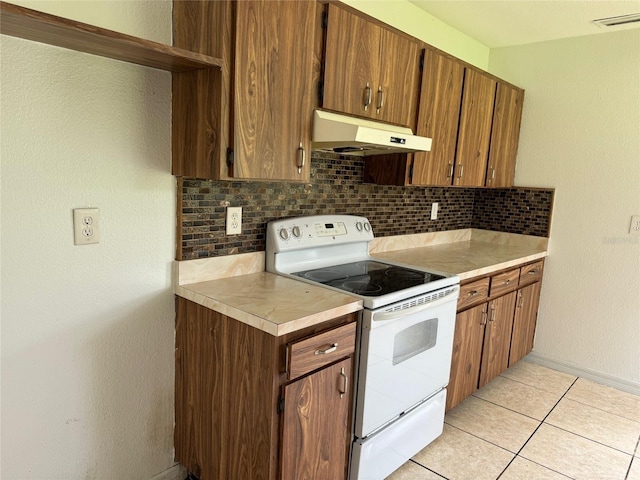 kitchen with white range with electric stovetop, backsplash, visible vents, and under cabinet range hood